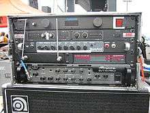An equipment rack from a modern bass player's performance system is shown. Several electronic devices are mounted onto the equipment rack.