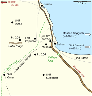 A large scale coloured map showing the Egyptian–Libyan border near the coast; dotted lines identify the border and frontier barbed wire fence while black dots represent important places and towns.