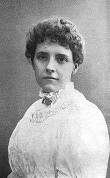 Black-and-white portrait of a white woman in a high-necked white dress