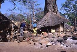 A Bedik village with a traditional house and two women working.