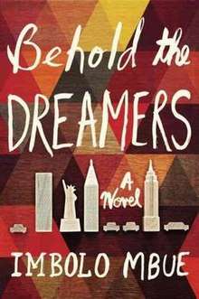 Cover art for the novel Behold the Dreamers by Imbolo Mbue. Cover designed by Jaya Miceli and features the novel's title and author's name handwritten over a wooden background painted with a repeating triangular pattern in contrasting colors. Small monochrome drawings of New York City landmarks, such as the Statue of Liberty and the Empire State Building, separate the novel's title from the author's name.