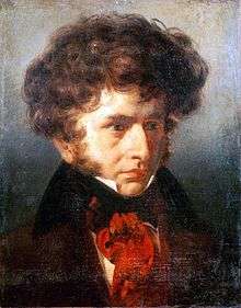 young white man with abundant curly brown hair and side-whiskers, wearing bright red cravat