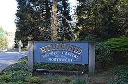 Welcome sign on Redmond Way readign "Redmond: Bicycle capital of the northwest" and featuring a pennyfarthing bicycle atop the written portion of the sign