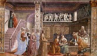 Fresco. St Anne rests in bed, in a richly decorated Renaissance room. Two women hold the newborn baby Mary, while a third prepares a tub to bath her. A group of richly dressed young women are visiting. On the left is a staircase with two people embracing near an upper door.