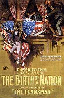 The theatrical poster for The Birth of a Nation depicting a hooded man carrying a burning cross on horse back.