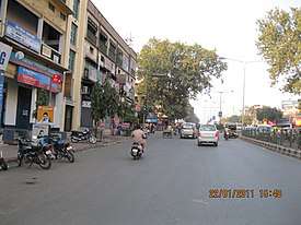 A divided road lined by 3-story shops