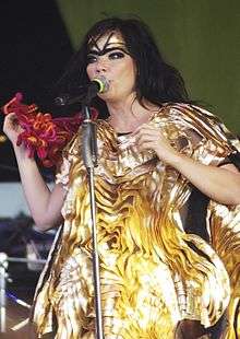 A picture of a woman dressed in yellow singing