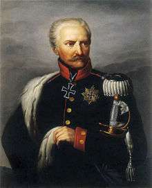 Painting shows a stern-looking man with white hair and a moustache. He wears a dark blue uniform with a silver epaulette. There is an Iron Cross at his neck and a Star of the Grand Cross of the Iron Cross on his left breast.