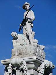 The Boer War Memorial in Dunedin. It is stark white and demonstrates New Zealand's patriotism by showing a man defending his fellow soldier.