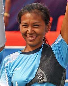 Laishram smiling at the camera in a blue jersey.