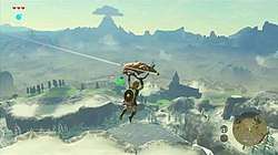 An in-game screenshot of the protagonist Link, paragliding across a vast world.