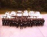 A fire department group photograph showing members and vehicles