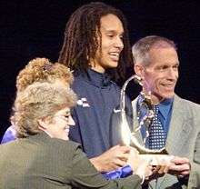 Brittney Griner holding a trophy amongst a group of people in 2012