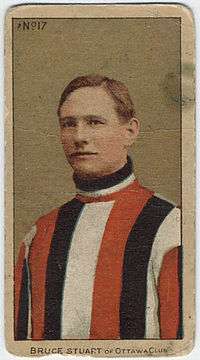 Brown-haired man in sweater of vertical red, black and white stripes
