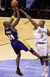 Kobe Bryant making a "fade" basketball shot attempt over defender Caron Butler