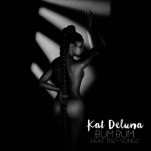 A black and white photo of a naked woman with her back to the camera. She has a long ponytail that covers her gluteal cleft and anus with the words "Kat DeLuna" in a bold white font and the words "BUM BUM FEAT. TREY SONGZ" in a faint white font.