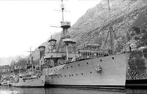 a black and white image of a ship alongside