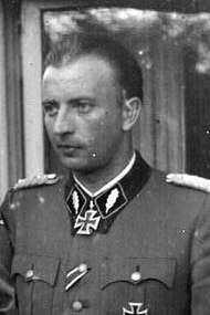 A black-and-white photograph of a man in semi profile wearing a military uniform and a neck order in shape of an Iron Cross.