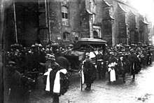 Photograph of Scheer's funeral procession; the horse-drawn hearse is accompanied by an honor guard