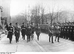 Werner von Blomberg inspects a parade in honor of the 40th anniversary of his joining the army. Soldiers with Guns stand to attention.
