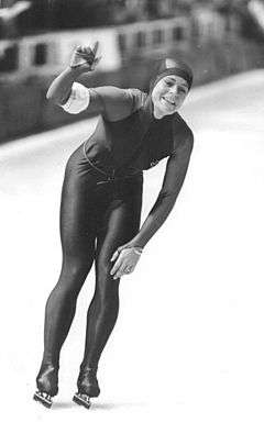 a woman standing in a speed skating outfit.