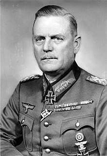 A black-and-white photograph of a man wearing a military uniform and a neck order in shape of an Iron Cross.