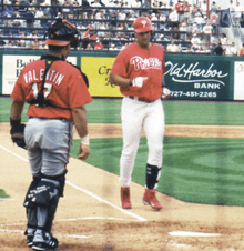 A man in a Philadelphia Phillies' uniform walking from third base to home plate