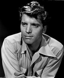 Burt Lancaster in 1947s Desert Fury—a handsome white man with light eyes and wavy light-colored hair, oval face, wearing a light-colored shirt, around 34 years of age.