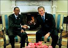 Kagame wearing a suit and Rwandan flag badge during a meeting with American President George W. Bush