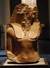 Upper part of the statue of an Egyptian pharaohs, its face acked off.