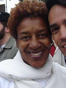 A woman in a white scarf, smiling