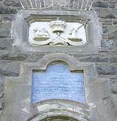Photograph of the inscription and relief above the tower's entrance