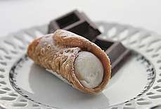 A basic cannolo lightly sprinkled with confectioner's sugar