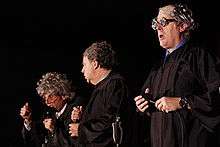 Three men onstage in judicial robes