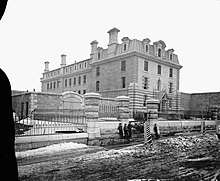 Black and white photo of a courthouse building with boys standing in the foreground