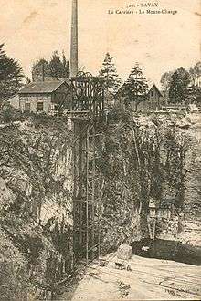 Old postcard showing the sandstone quarry with its hoist, a chimney reveals the presence of steam to operate the equipment; rock layers are nearly vertical