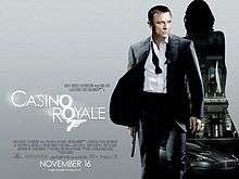 The poster shows Daniel Craig as James Bond, wearing a business suit with a loose tie and holding a gun. Behind him is a silhouette of a woman showing a building with a sign reading "Casino Royale" and a dark grey Aston Martin DBS below the building. At the bottom left of the image is the title "Casino Royale"&nbsp;– both "O"s stand above each other, and below them is a 7 with a trigger and gun barrel, forming Bond's codename: "Agent 007"&nbsp;– and the credits.