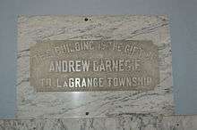 An image of the marble plaque stating that the building was a gift from Andrew Carnegie to Lagrange Township for a free library.