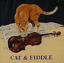 Cat standing on a table with a fiddle and sheet music, from pub sign as seen in 2009