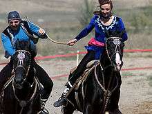 Male and female riders on black horses