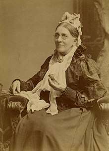 portrait photograph of Hopley seated, holding a baby turtle in her hand