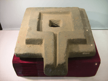 Photograph of a large stone yoni in a museum display case