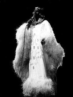 Black-and-white photo of Celia Cruz onstage in a fluffy gown