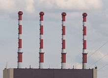 Close-up view of four red and white chimneys.