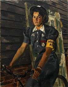 A girl in ARP uniform, wearing a tin helmet and riding a bike