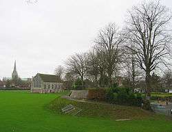  Site of the Chichester gaol, this modern photograph, shows the remains of the motte in Priory Park, that was once home to the castle keep. It is all that remains of a defensive motte and bailey built by the Normans in the 11th century. Behind the mound is the former guildhall. After the dissolution the land was given over to the Duke of Richmond whose descendants finally passed it over to the city who in turn made it a public park.