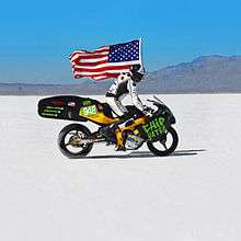 Chip Yates Rides the electric motorcycle at Bonneville carrying an American Flag.