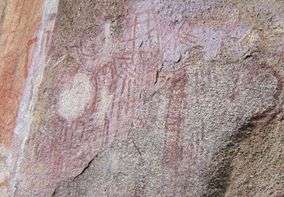 A picture of various red markings on a stone wall.
