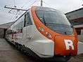 The front side of a Civia train. A big 'R' (standing for Rodalies de Catalunya) is painted on the front.