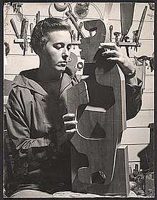 Portrait of Claire Falkenstein, with one of her wooden sculptures, ca. 1936